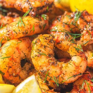 Air fryer shrimp with lemon wedges.