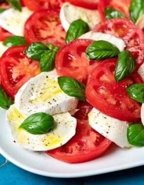 A caprese salad on a white platter.