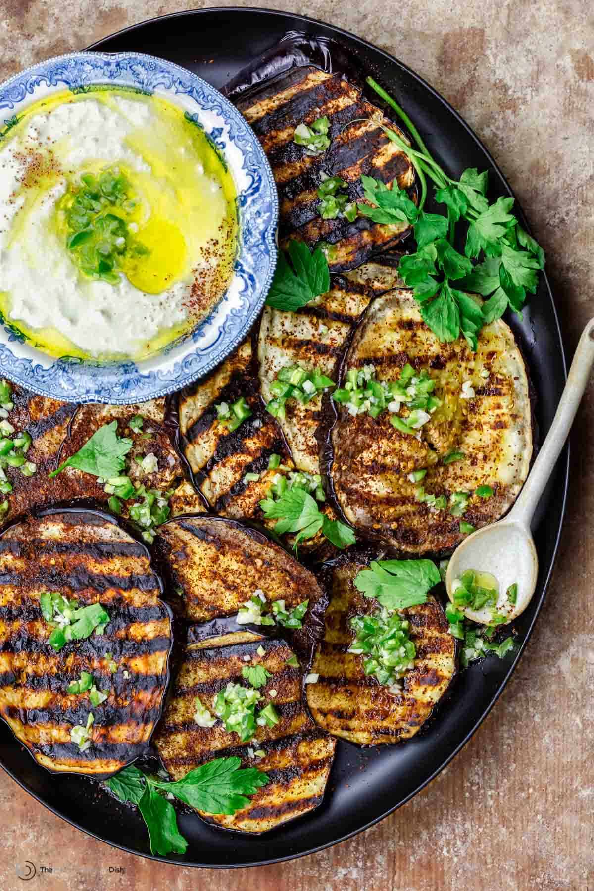 Mediterranean eggplant slices topped with infused olive oil with a serving dish of whipped feta