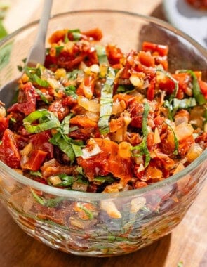 Sun dried tomato salsa in a bowl with a spoon.